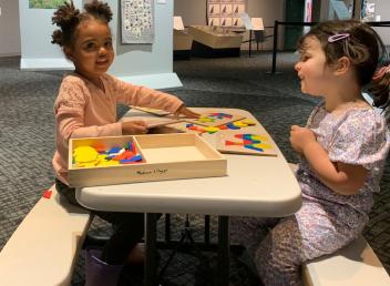 2 kids work on a puzzle.