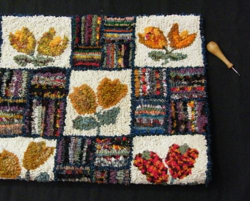 Image of a Hooked rug with a floral pattern.