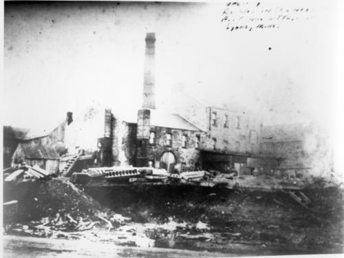 A faded photograph of attached stone buildings and chimneys belonging to the General Mining Association in Sydney Mines, Cape Breton.