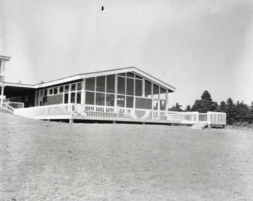 A black and white photograph taken in 1960 of one of the three buildings comprising the new Silver Dart Motel in Baddeck. The photo was taken from the front of the property. The photo was taken by Abbass Studios and is courtesy of the Beaton Institute of Cape Breton University, Reference Number: A-6051.