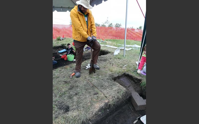 The archaeologist marks the area of sod he will remove.