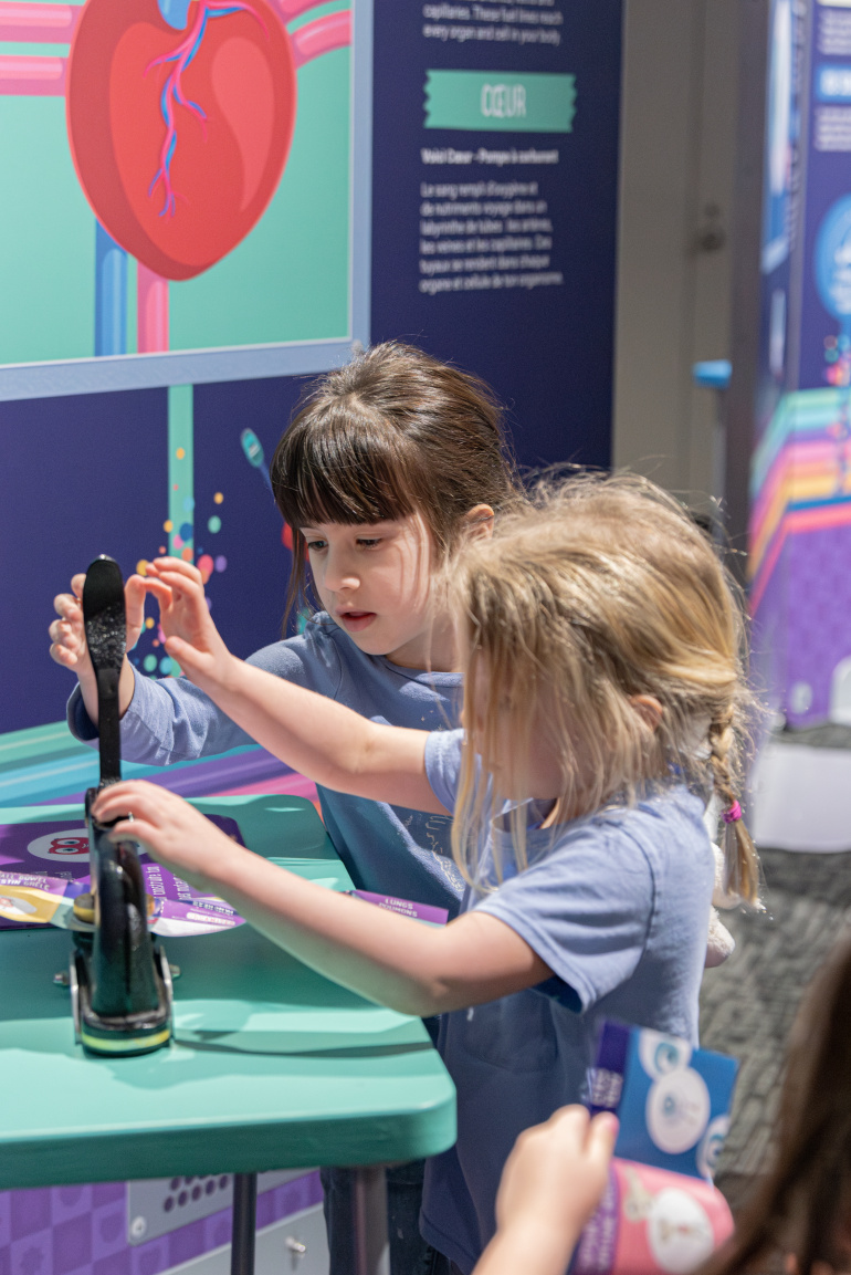 Two children collecting stamps in the Mighty Engine exhibit.