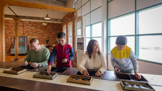 Family sorting chocolates at the Museum of Industry.